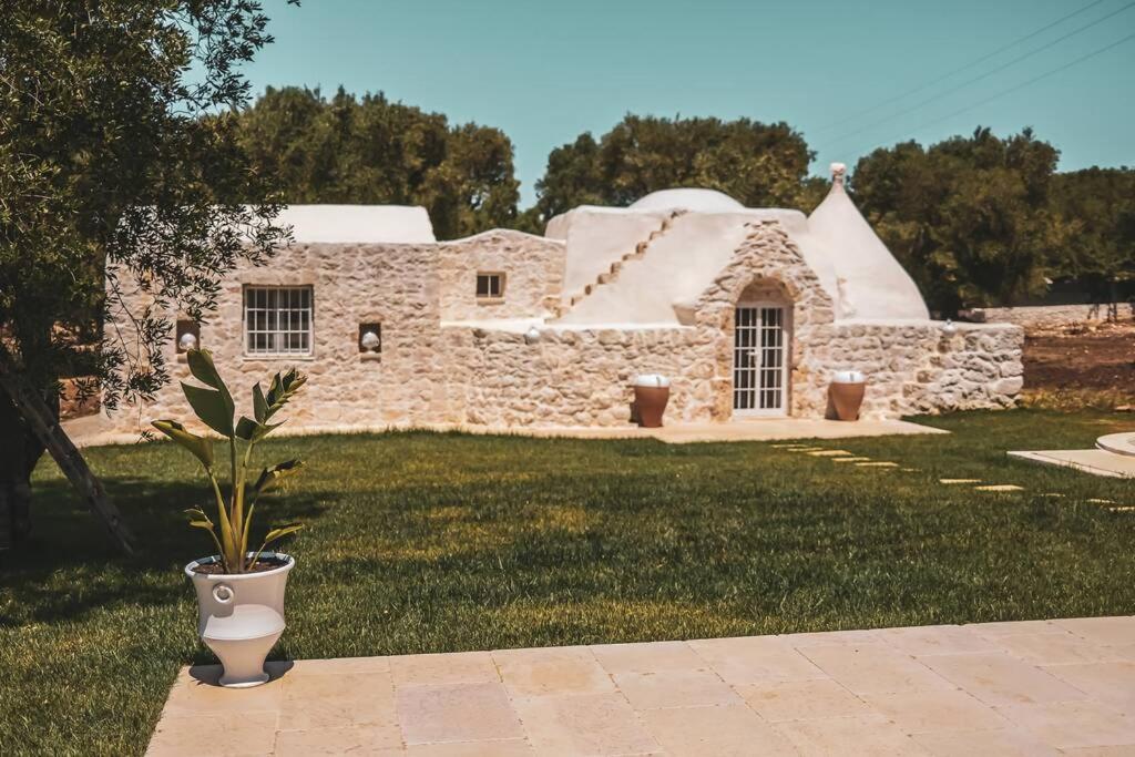 une plante en pot devant une maison en pierre dans l'établissement Tenuta Trullo Acquaro Ostuni, à Ostuni
