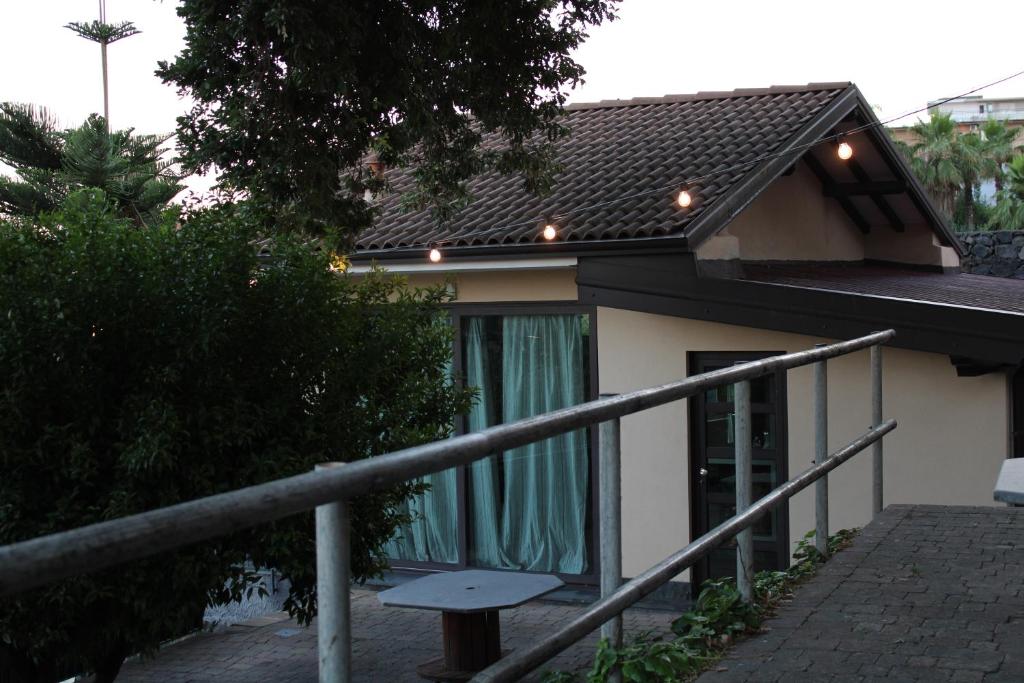 une maison avec un rideau vert devant elle dans l'établissement Lily house, à Gravina di Catania