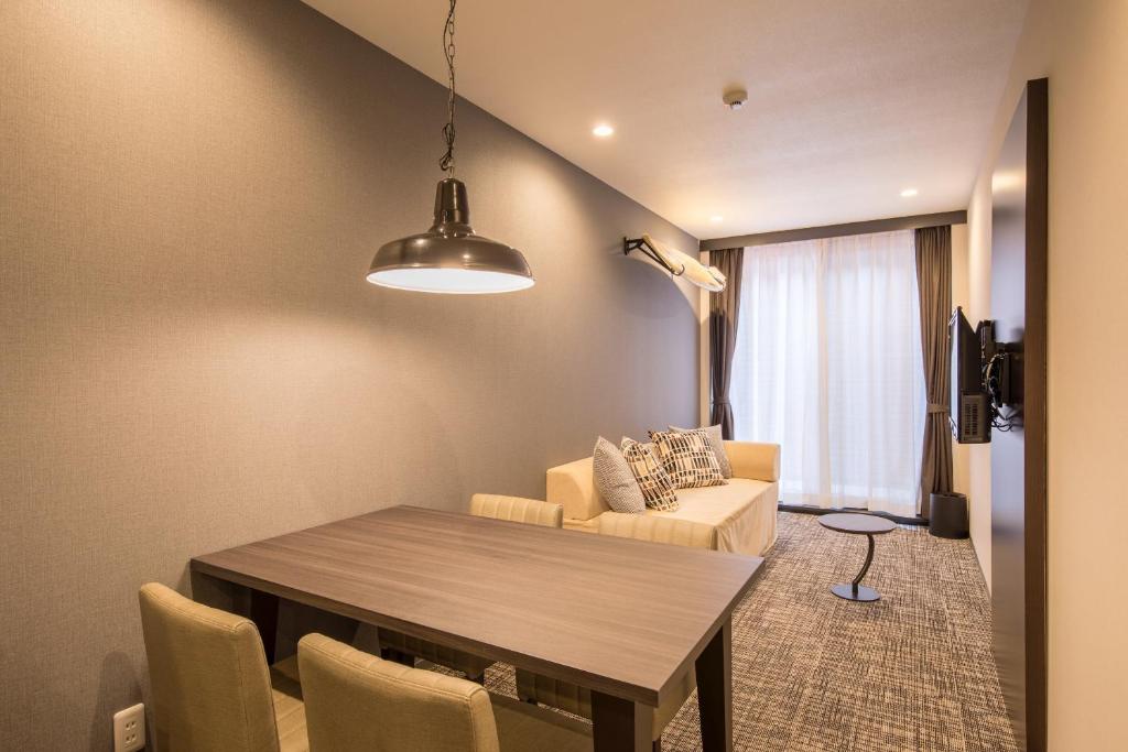un salon avec une table et un canapé dans l'établissement HOTEL R9 Kujukuri "ex Casual Resort COFF Ichinomiya", à Ichinomiya