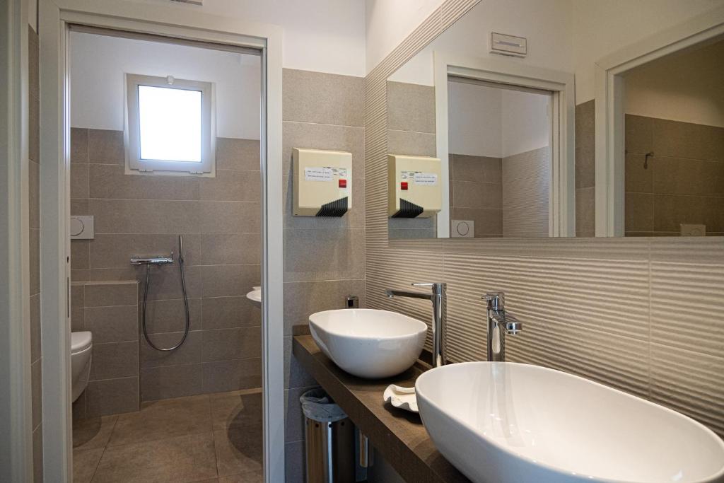 une salle de bain avec un lavabo, une baignoire et une douche dans l'établissement Hotel Cormoran Riccione, à Riccione