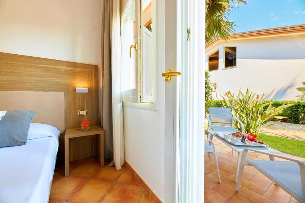 une chambre avec un lit et un balcon avec une table dans l'établissement Paestum Inn Beach Resort, à Paestum 69 autres photos