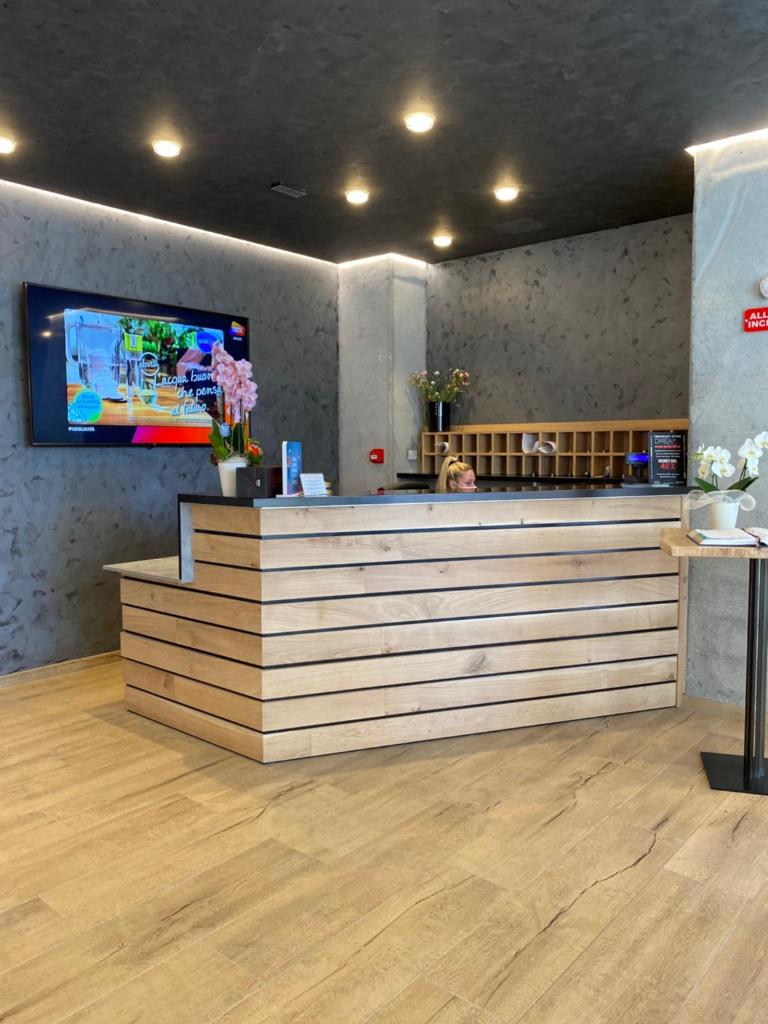 une femme assise à un bar dans un restaurant dans l'établissement Hotel Ivana, à Lido di Jesolo