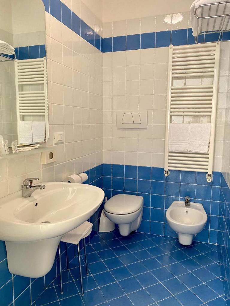 La salle de bains bleue et blanche est pourvue d'un lavabo et de toilettes. dans l'établissement Hotel Ivana, à Lido di Jesolo 29 autres photos
