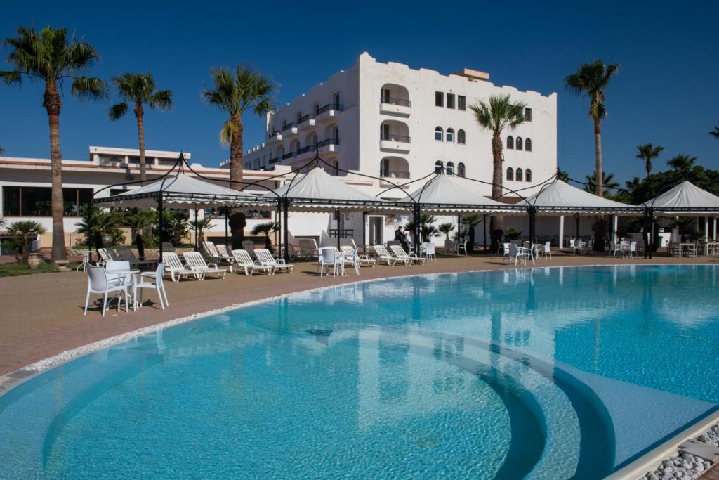 une grande piscine devant un immeuble dans l'établissement Hotel Baia D'oro, à Licata