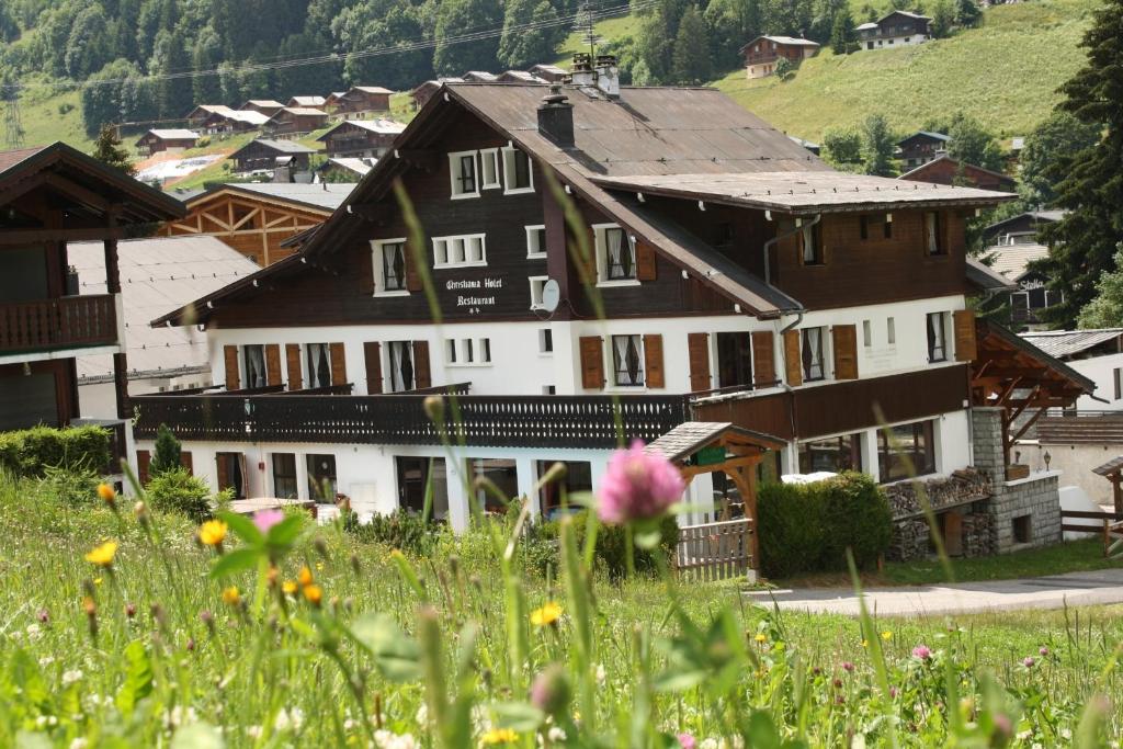 une maison dans un village avec un champ de fleurs dans l'établissement Hotel Le Christiania, aux Gets