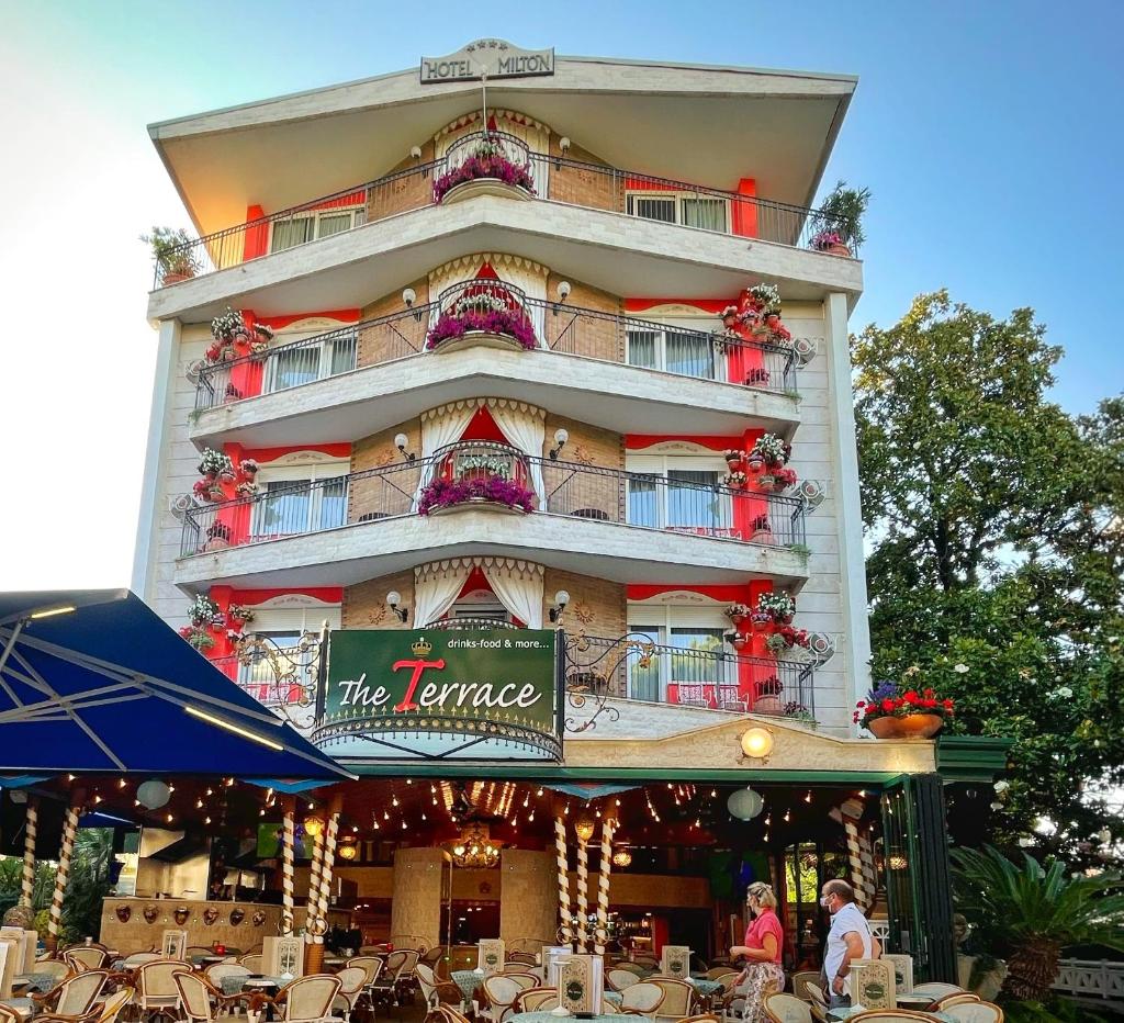 un grand bâtiment avec un restaurant en face de lui dans l'établissement Milton Boutique Hotel - Adults Only, à Lido di Jesolo