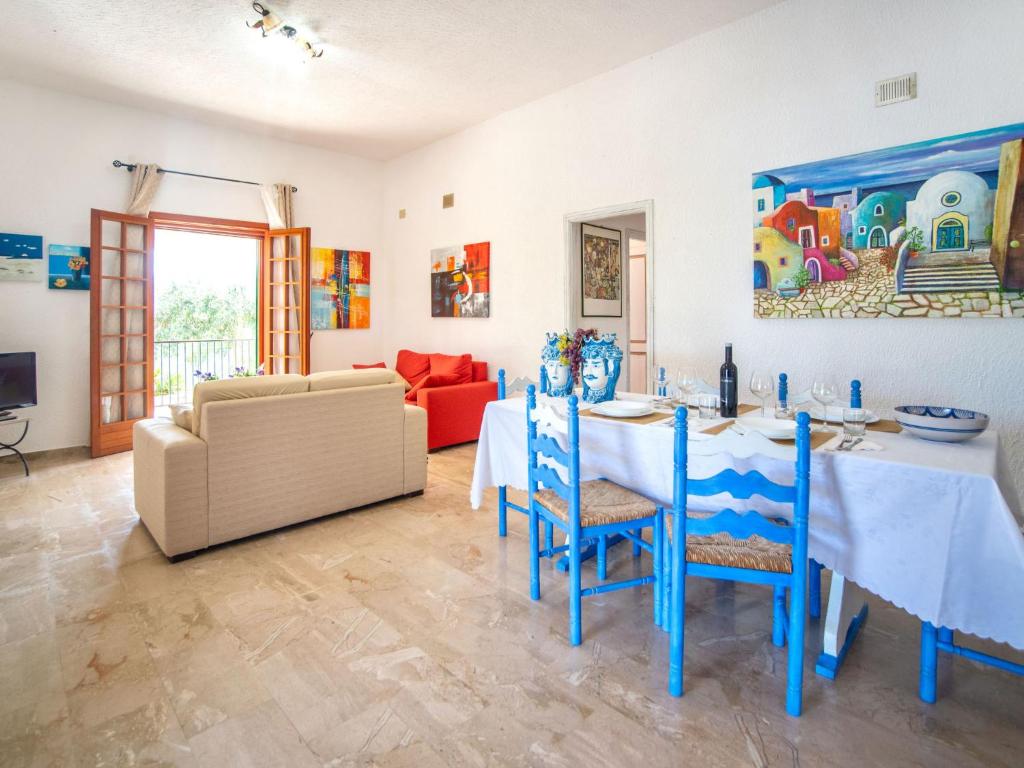 une salle à manger avec une table, des chaises et un canapé dans l'établissement Villa La Vela by Interhome, à Scopello