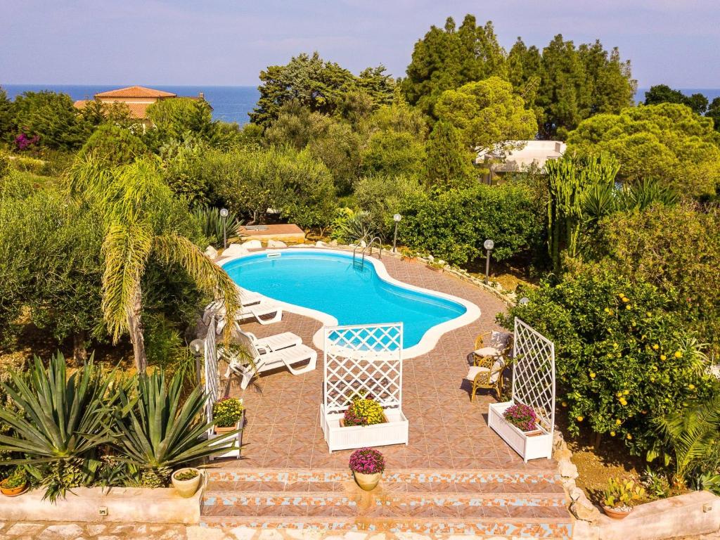 une image d'une piscine dans un jardin dans l'établissement Villa La Vela by Interhome, à Scopello