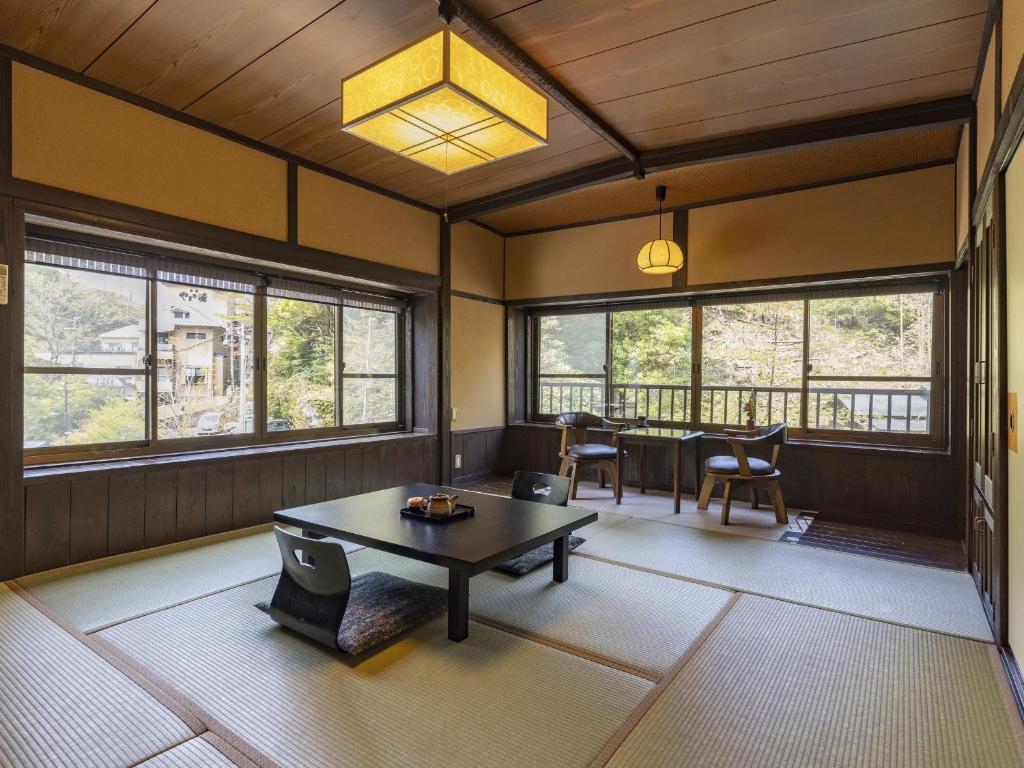 - un salon avec une table et quelques fenêtres dans l'établissement Okyakuya, à Minamioguni