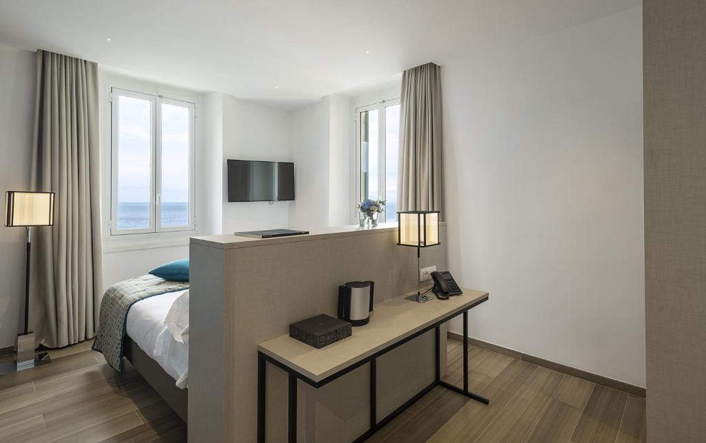 une chambre d'hôtel avec un lit et un bureau avec une télévision dans l'établissement Sublimis Boutique Hotel Adults-Only, à Camogli