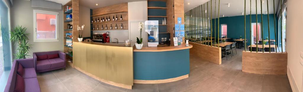 un bar dans un restaurant avec des chaises violettes et un comptoir dans l'établissement MAR60 Apartments, à Caorle