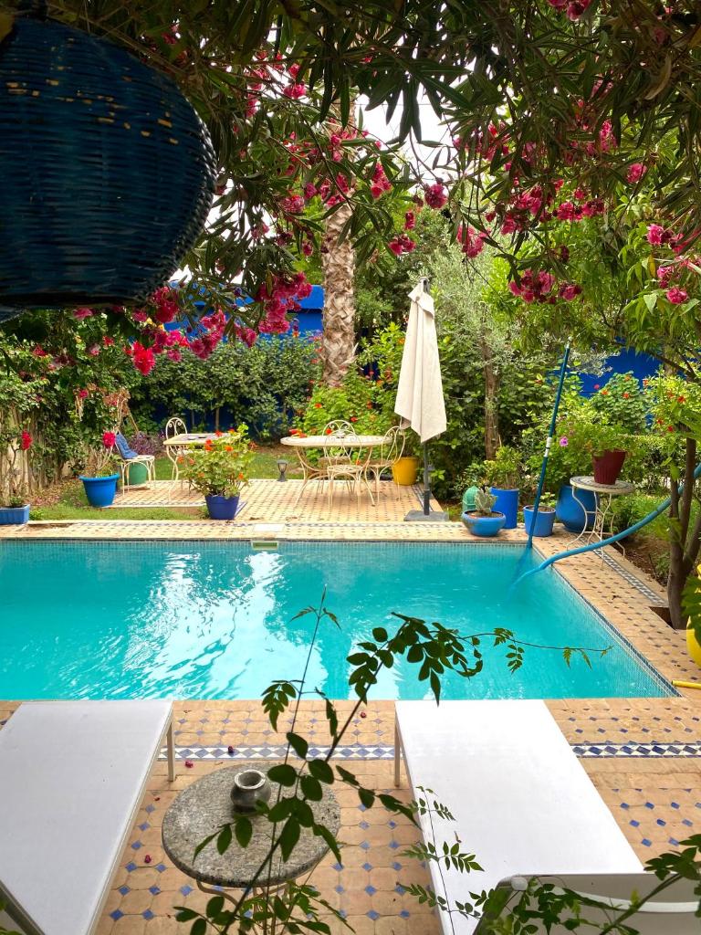 - une piscine avec une table et un parasol dans l'établissement Riad Jean Claude, à Fès