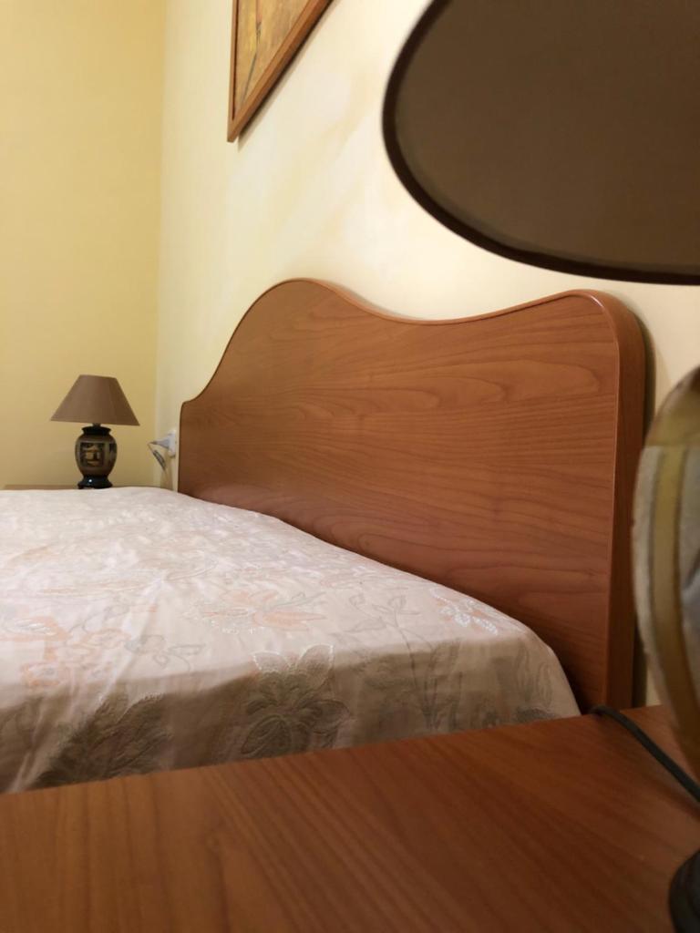 - un lit avec une tête de lit en bois dans l'établissement Tiglio Vieste, à Vieste