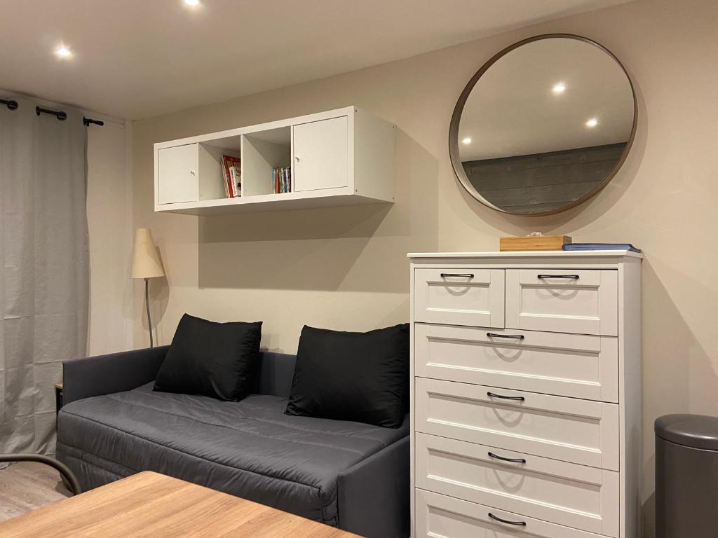 un salon avec un canapé et un miroir dans l'établissement Appartement Studio rénové le Corbier 4 personnes 22m2 domaine les Sybelles Classé 2 étoiles label qualité le corbier, à Villarembert