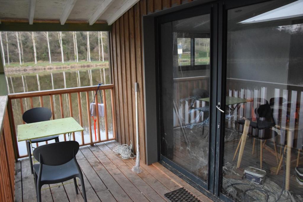 une véranda avec une table et des chaises dans l'établissement bateau du moulin girault, à Panzoult