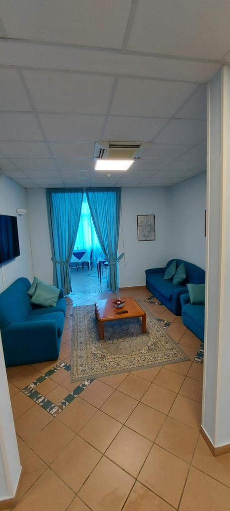 - un salon avec des canapés bleus et une table basse dans l'établissement Hotel Savina, à Rimini