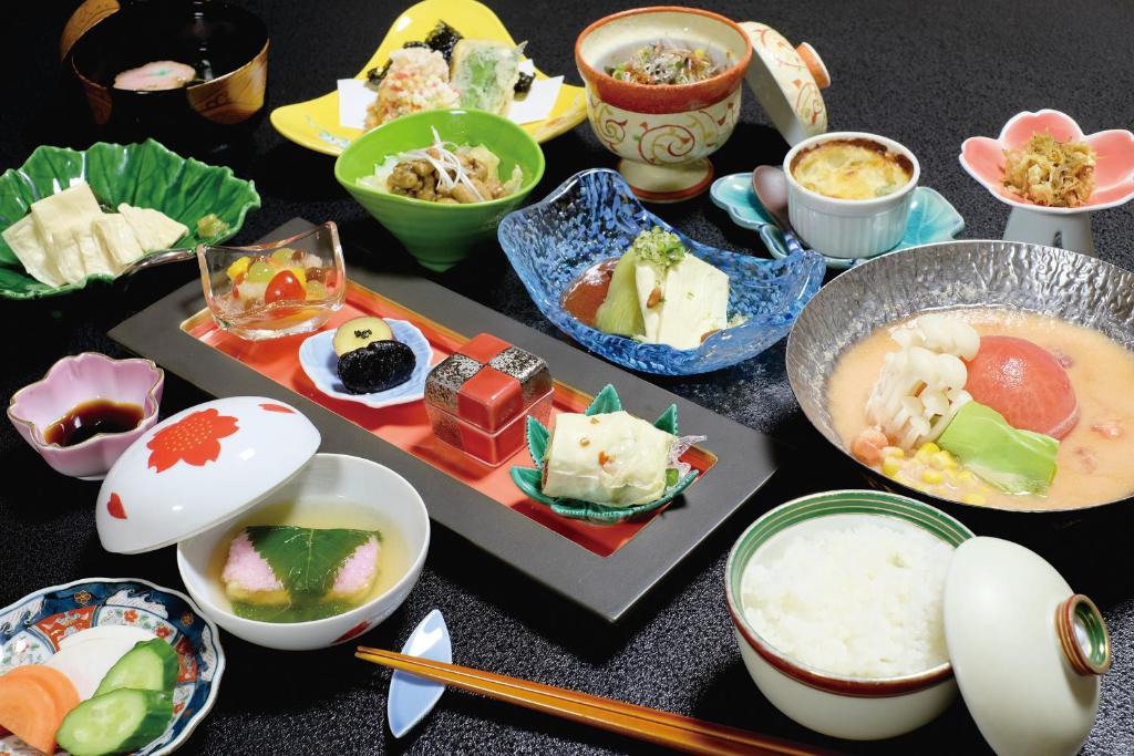 une table recouverte de bols et de assiettes de nourriture dans l'établissement Temple Lodging Shukubo Kakurinbo, à Minobu