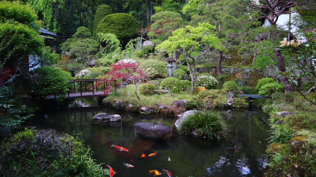 un jardin avec un étang avec des cerfs-volants dans l'établissement Temple Lodging Shukubo Kakurinbo, à Minobu
