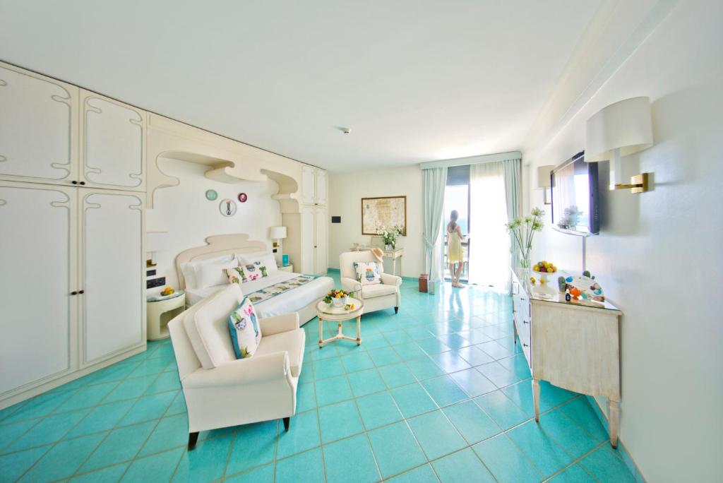 Cette grande chambre comprend 2 chaises et un lit. dans l'établissement Grand Hotel Terme, à Margherita di Savoia