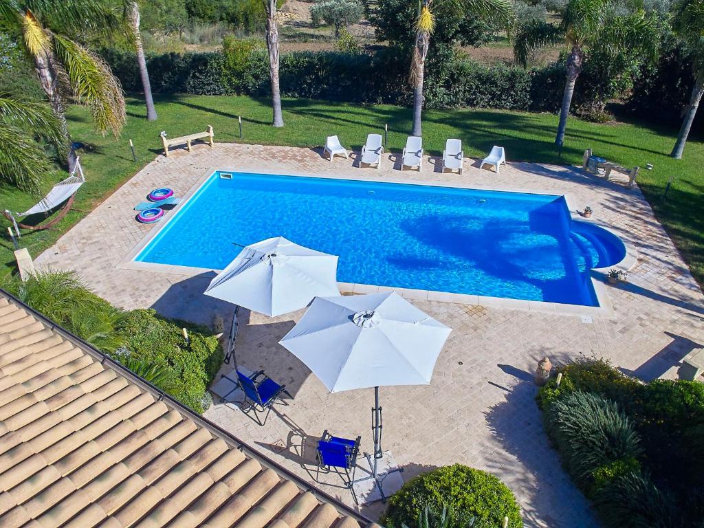 une vue aérienne d'une piscine avec des parasols dans l'établissement Villa Bel Villa by Interhome, à Marinella di Selinunte