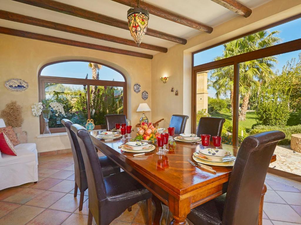 une salle à manger avec une table et des chaises en bois dans l'établissement Villa Bel Villa by Interhome, à Marinella di Selinunte