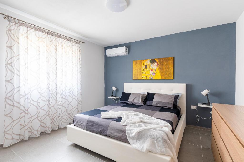 une chambre avec un lit et un mur bleu dans l'établissement Elegante Villa con Piscina privata a Scopello, à Castellammare del Golfo