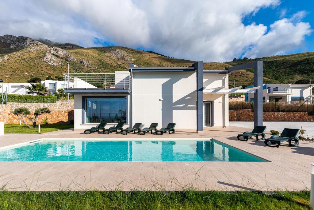 une maison avec une piscine devant une maison dans l'établissement Elegante Villa con Piscina privata a Scopello, à Castellammare del Golfo