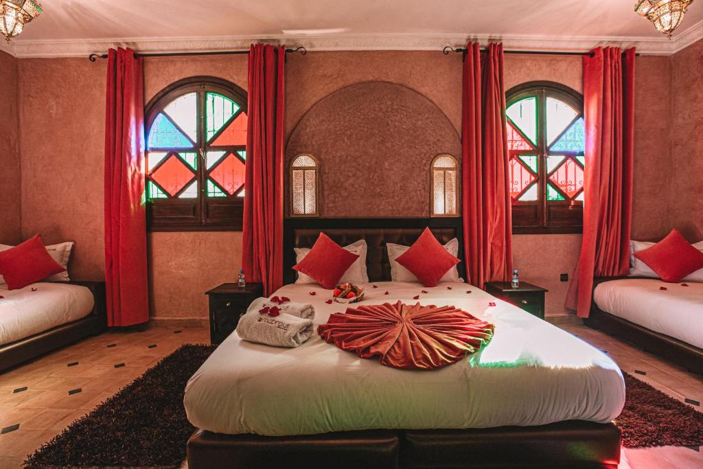 - une chambre avec un grand lit et des rideaux rouges dans l'établissement Riad Mabrouk, à Marrakech