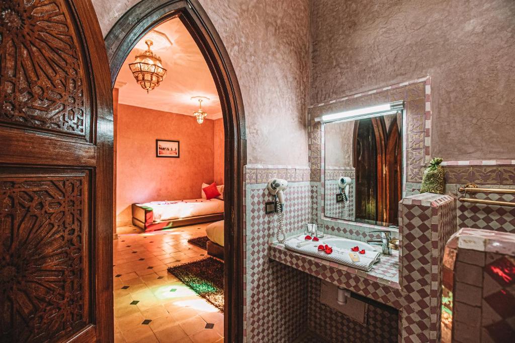 une salle de bain avec baignoire et miroir et une chambre dans l'établissement Riad Mabrouk, à Marrakech
