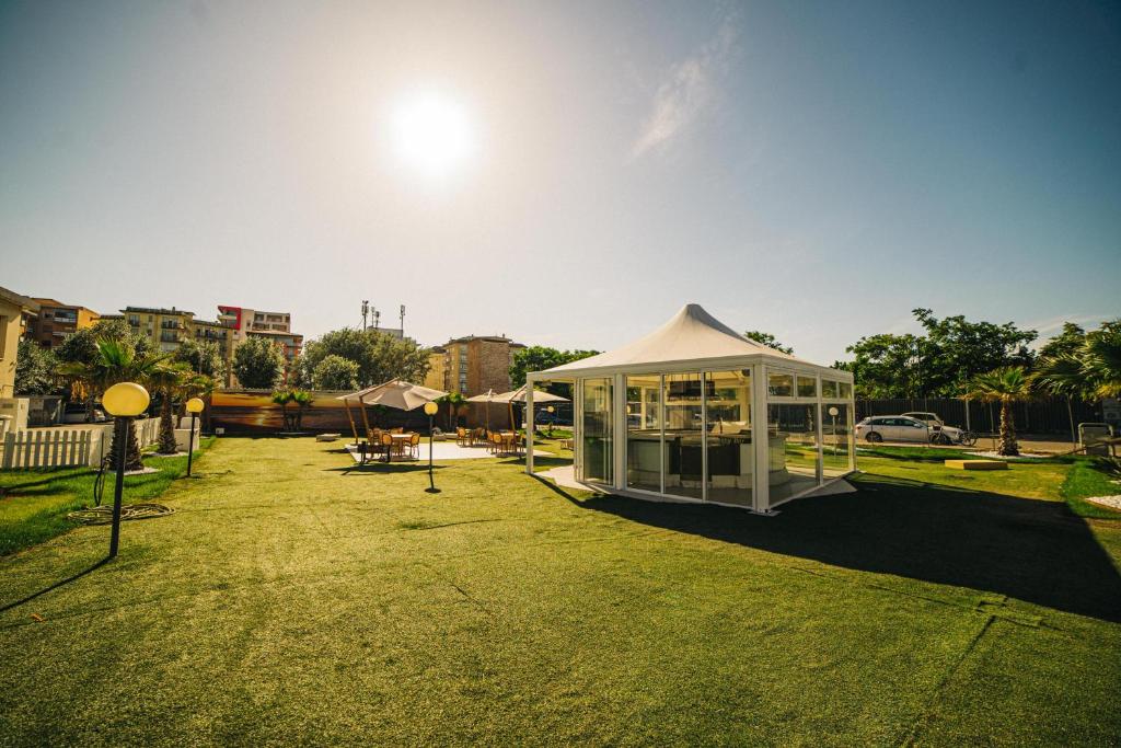 - un bâtiment blanc avec une tente sur une pelouse dans l'établissement Hotel Park, à Sottomarina 50 autres photos