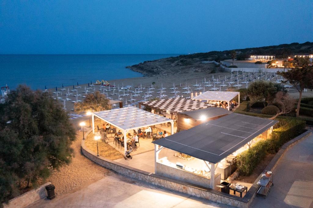- une vue de tête sur un lieu avec des tentes blanches et l'océan dans l'établissement Hotel Club Eloro, à Noto Marina