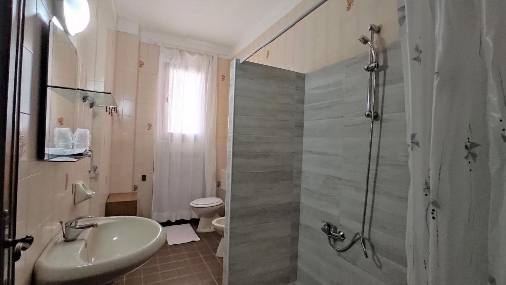 une salle de bain avec douche, lavabo et toilettes dans l'établissement Hotel De Amicis, à Riccione