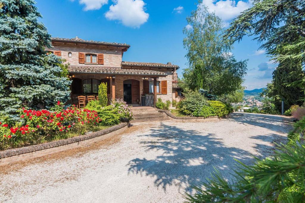 une maison en pierre avec une allée et des fleurs dans l'établissement Villa Durante, à Cagli