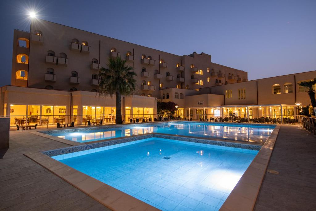 - une piscine en face de l'hôtel la nuit dans l'établissement Hotel Club Eloro, à Noto Marina