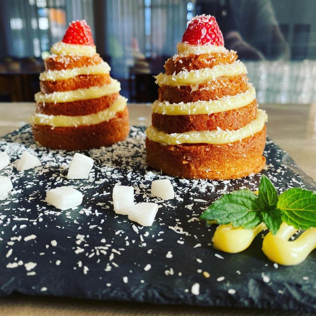 deux types de desserts assis sur une assiette noire dans l'établissement Hotel Levante Convenzionato ITALIA IN MINIATURA, à Riccione