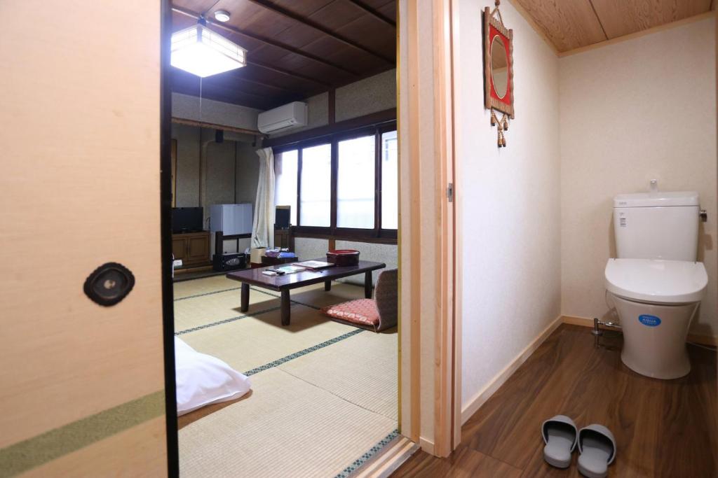 Il comprend un salon et une salle de bains pourvue de toilettes. dans l'établissement Hinode Ryokan, à Ise