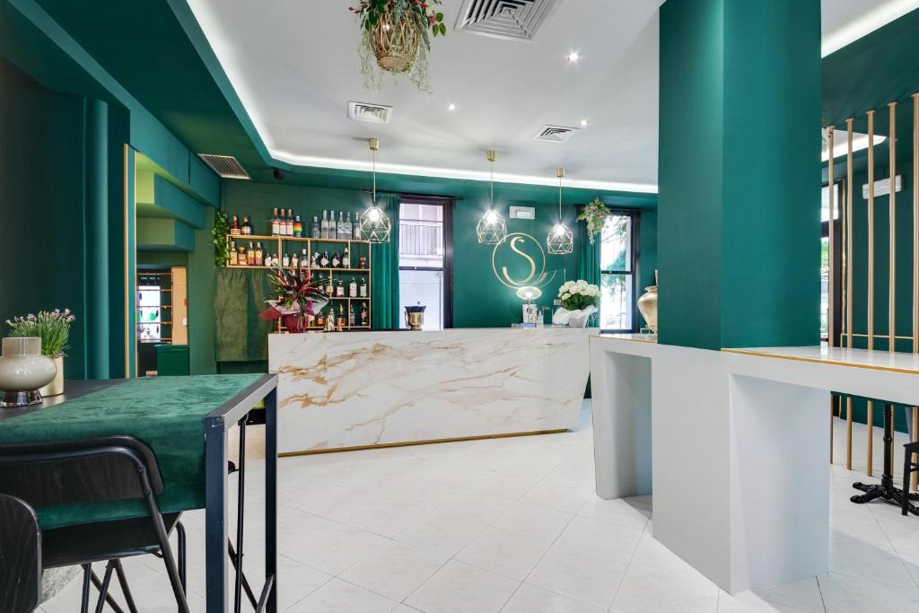 un bar avec des murs verts et un comptoir en marbre dans l'établissement Hotel Sorriso, à Rimini