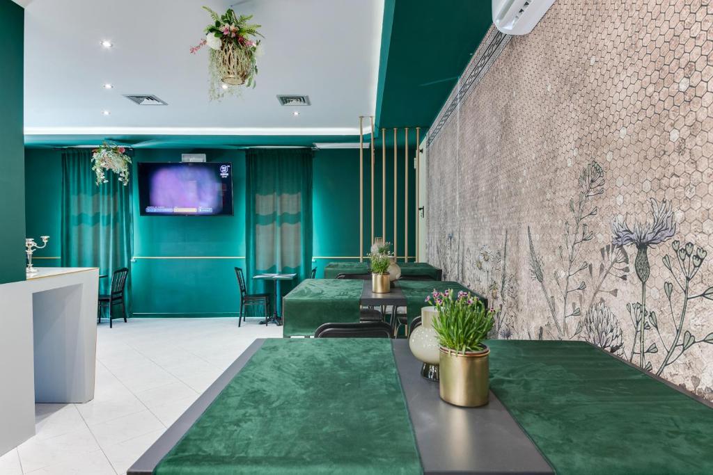 - un hall avec des murs verts et de la moquette verte dans l'établissement Hotel Sorriso, à Rimini