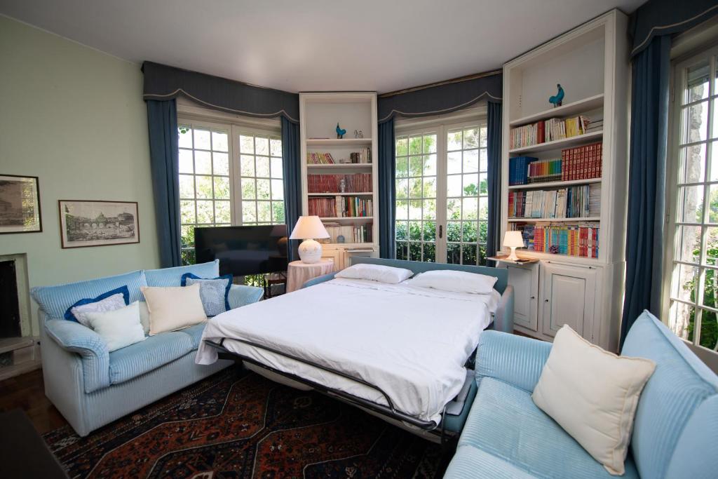 - une chambre avec un lit et deux chaises bleues dans l'établissement Villa Sofia, à San Felice del Benaco