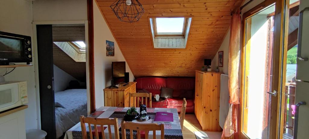 une petite chambre avec une table et une chambre dans l'établissement Appartement T2 à BERNEX avec WiFi, vue sur montagne, à Bernex
