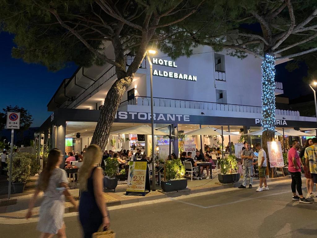 un groupe de personnes marchant devant un magasin dans l'établissement Hotel ALDEBARAN, à Lido di Jesolo