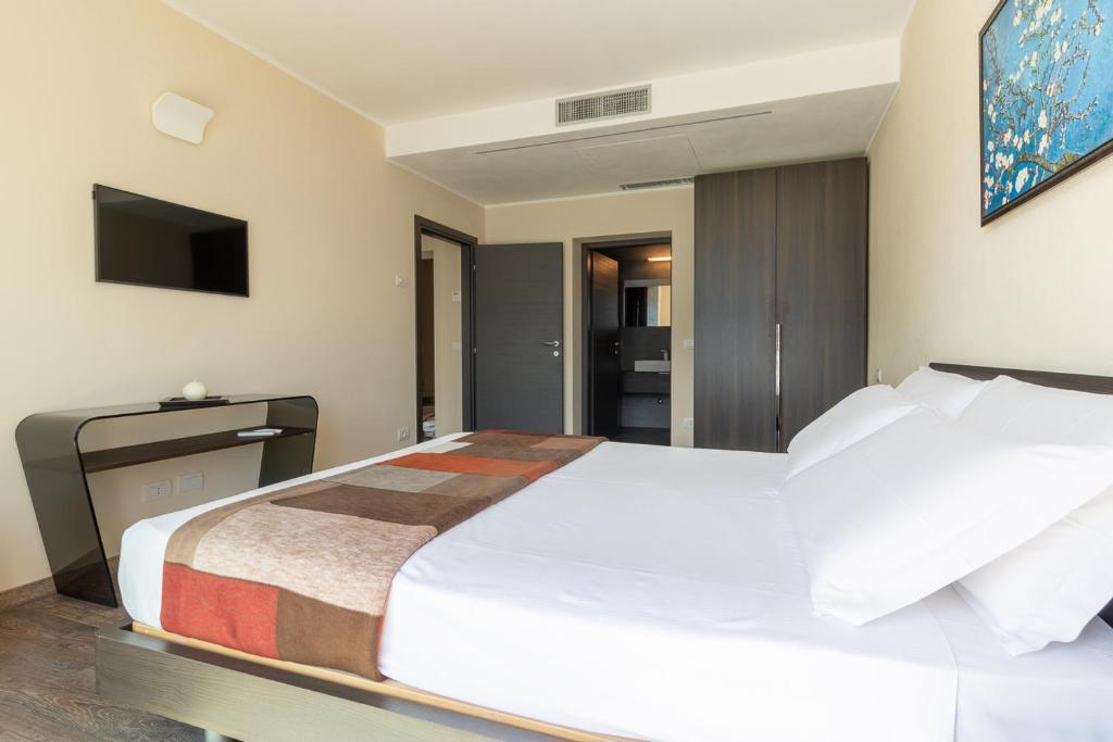 une chambre avec un grand lit blanc et une télévision dans l'établissement Villa Del Sasso - Cremia, à Cremia 50 autres photos