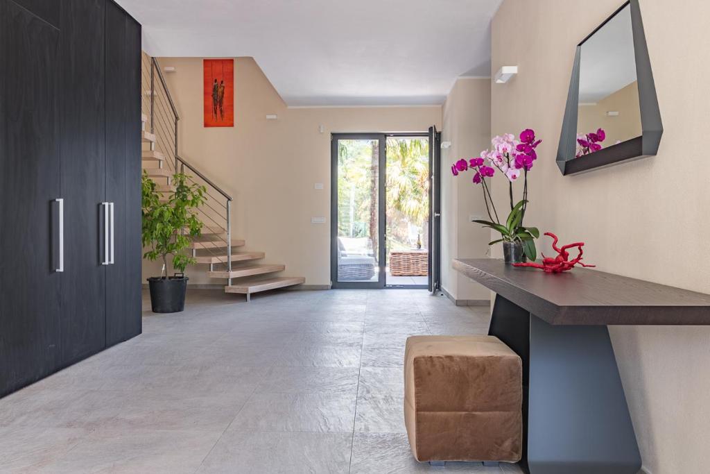 un couloir avec des fleurs violettes, un comptoir et des escaliers dans l'établissement Villa Del Sasso - Cremia, à Cremia