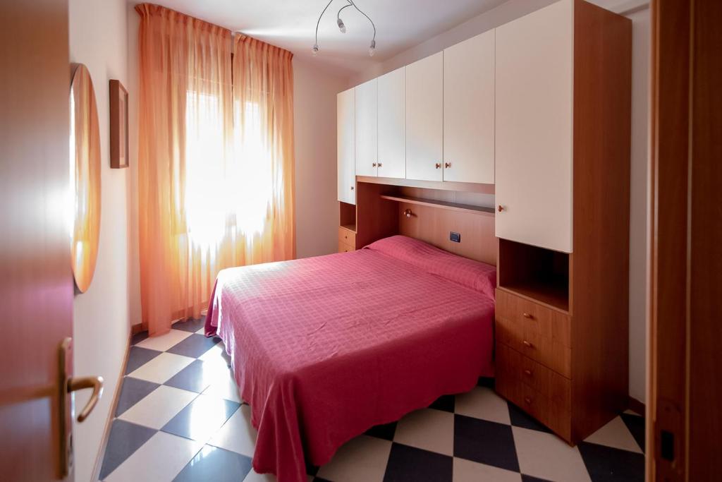 une chambre avec un lit rouge et une fenêtre dans l'établissement Milan Residence, à Rosolina Mare