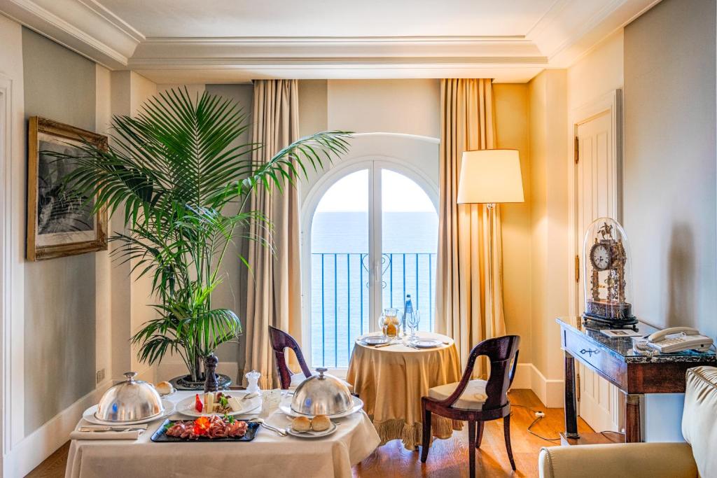 une salle à manger avec deux tables et une grande fenêtre dans l'établissement Excelsior Palace Portofino Coast, à Rapallo