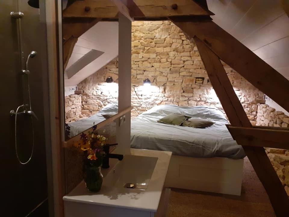une chambre avec un lit dans un mur de pierre dans l'établissement Gite Ramana, à Montcléra 21 autres photos