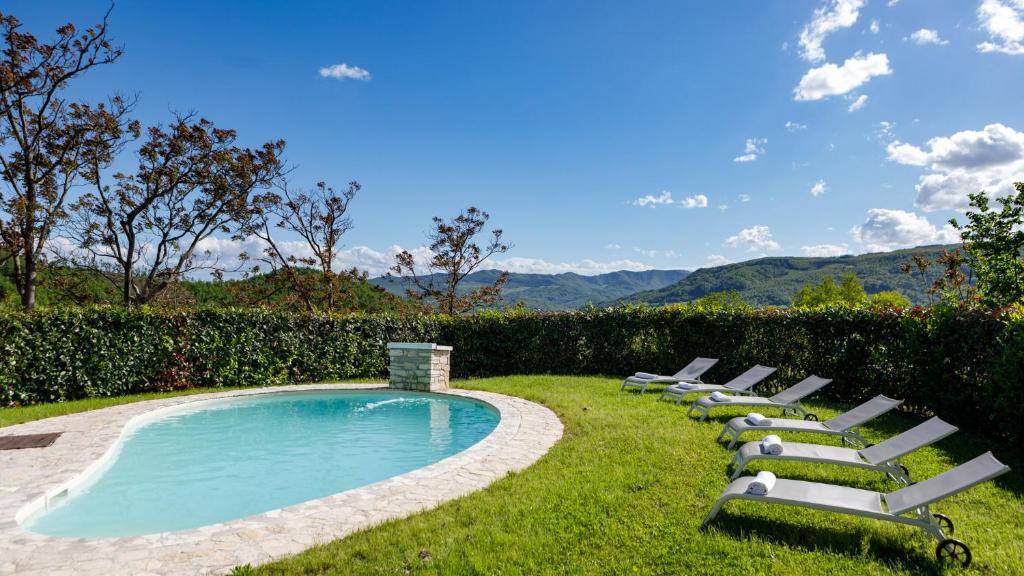 une rangée de chaises longues à côté d'une piscine dans l'établissement Villa Agostini 10, Emma Villas, à Casa Nuova