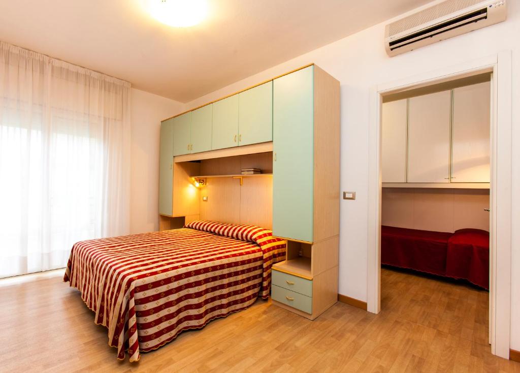 une petite chambre avec un lit et une armoire dans l'établissement Hotel Arizona, à Lido di Jesolo