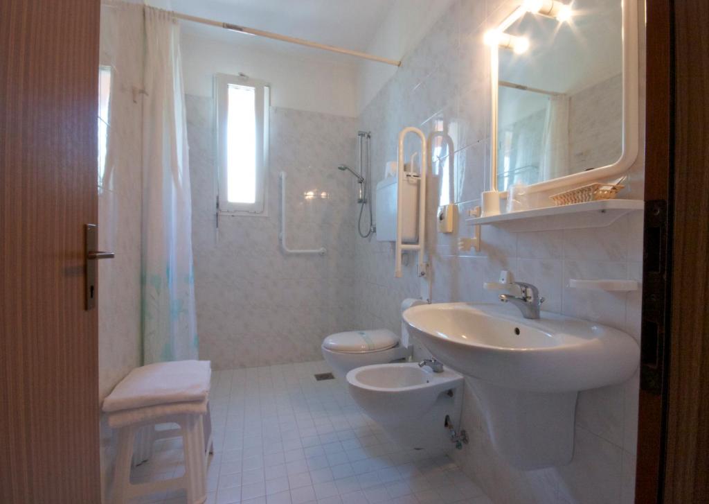 une salle de bain blanche avec un lavabo et des toilettes dans l'établissement Hotel Toledo, à Lido di Jesolo