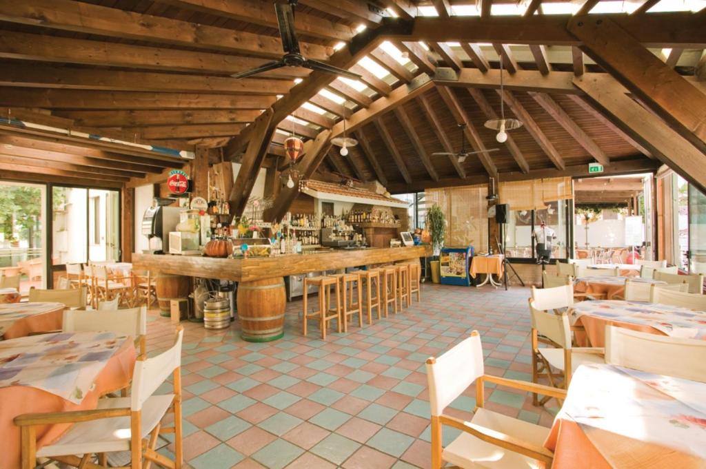 un restaurant avec un bar, des tables et des chaises dans l'établissement San Giorgio Savoia, à Bellaria-Igea Marina